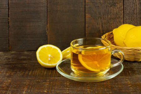 Cup of hot tea and fresh lemon on rustic wooden table.の写真素材