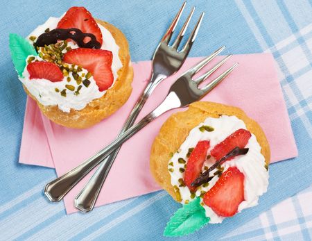 Closeup of two pastries with cream and strawberriesの写真素材