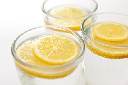 Fresh lemon slices in sparkilng water glassesの写真素材