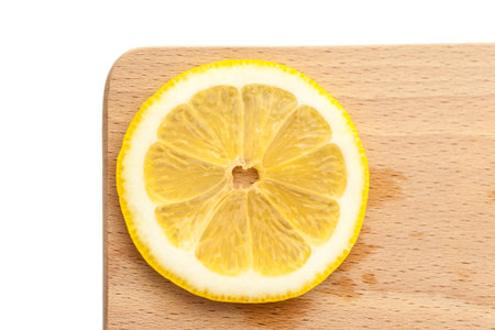 Single slice of lemon on a cutting board, simple and minimalistの写真素材