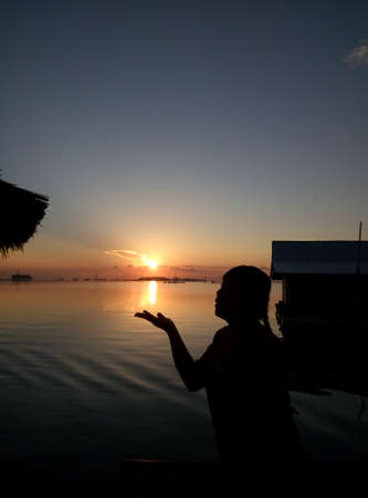 Silhouette of a woman at sunset on the lake. Silhouette of a woman at sunset.の写真素材