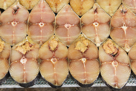 Stack of scomberomorus fish sliced (Cantonese salted fish) at fish market jetty. For seafood, food,...