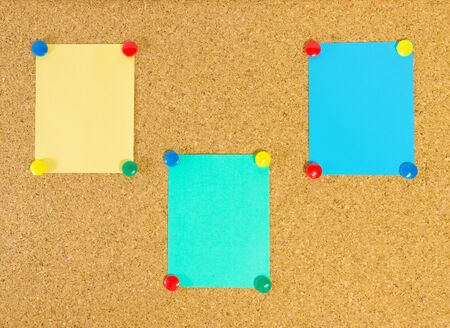 Cork message board with three paper notesの写真素材