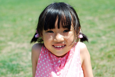 Happy Asian little girl on grass