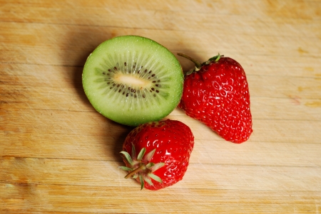 Strawberry and kiwi on a chopping boardの写真素材