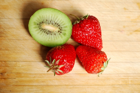 Strawberry and kiwi on a chopping boardの写真素材