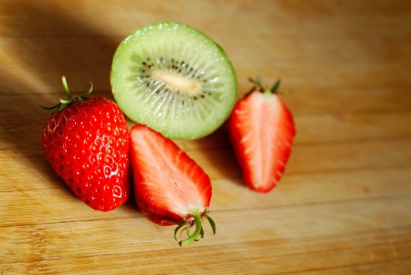 Strawberry and kiwi on a chopping boardの写真素材