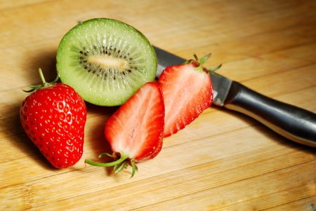 Strawberry and kiwi on a chopping boardの写真素材