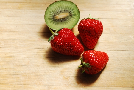 Strawberry and kiwi on a chopping boardの写真素材