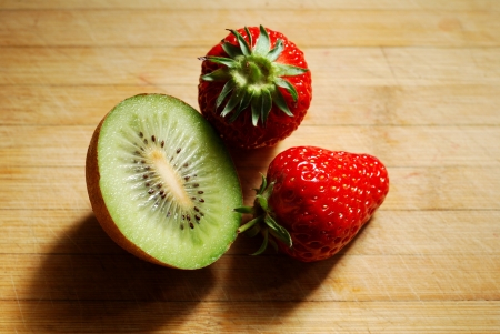 Strawberry and kiwi on a chopping boardの写真素材