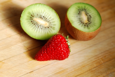 Strawberry and kiwi on a chopping boardの写真素材
