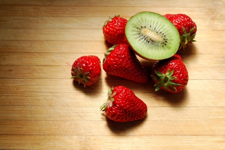 Strawberry and kiwi on a chopping boardの写真素材