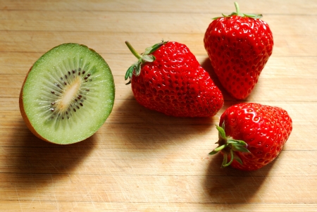 Strawberry and kiwi on a chopping boardの写真素材
