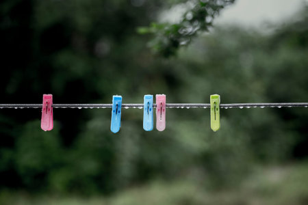 Rain water stick on clothespin and clothesline look conflict because the clothespin and clothesline are used for dry clothes by sunlight due to this one fix out door. So this can interpret as some stuff is useless when it is on the wrong time or wrong plaの写真素材