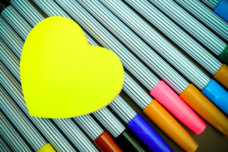 Yellow heart shape paper on color pensの写真素材