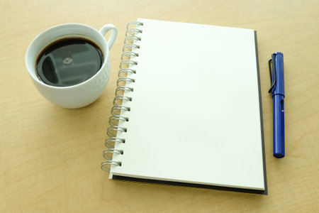 Notebook pen and coffee on deskの写真素材