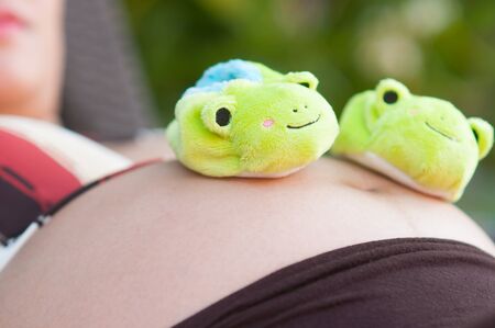 frog shoes on pregnant womanの写真素材