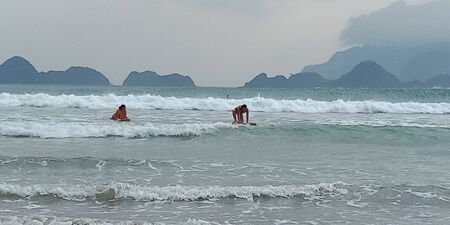 surfing on the beach is very pleasant with the beach waves that are not too bigの写真素材