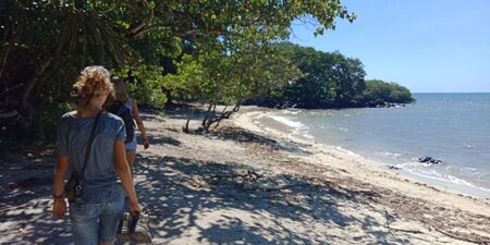 blond young woman walking on the beachの写真素材