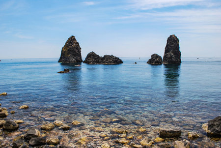 A scenic view of the sea stacks in Acitrezza. Sicilyの写真素材