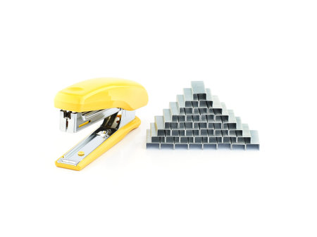 Yellow stapler with staples on a white 