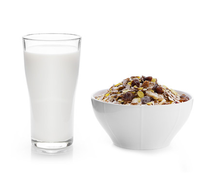  milk in the glass and pile of muesli on white backgroundの写真素材