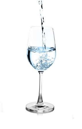 pouring water on a glass on white backgroundの写真素材