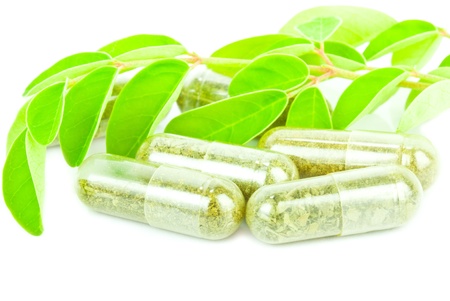 herbal medicine pills with green plant on white background の写真素材