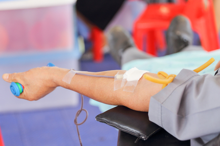 arm of a donor donating blood at hemotransfusion stationの写真素材