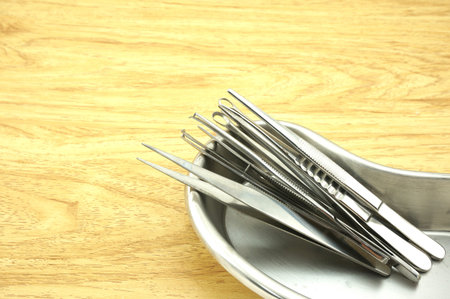 Many types of forceps made of stainless steel and placed in a bowl-shaped kidney