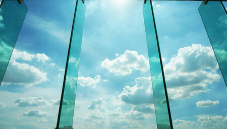 Glass window with reflection of clouds,  outside modern offifce building.                     の写真素材