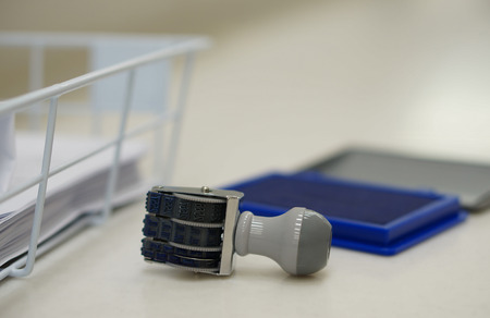 The date stamp placed close to ink pad on desk at office.の写真素材