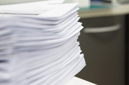 Pile of copy document placed on white desk at office.
