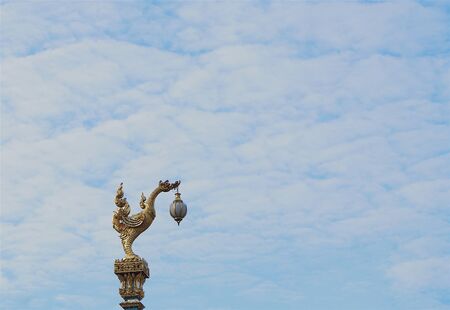 Thai traditional street lamp, beautiful golden swan on blue sky background.の写真素材