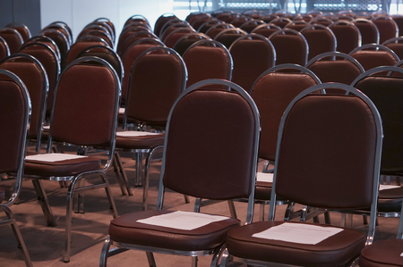 Empty classroom contained with brown chairs and document on top.の写真素材