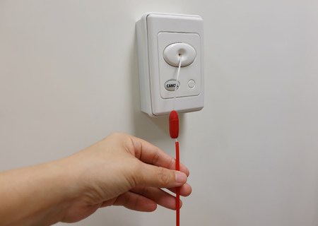 Pulling red emergency call switch for calling nurse to rescue in patient shower room.の写真素材