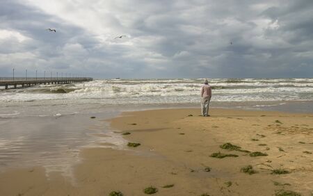 A lonely man on the shore of the Black Sea in a stormの写真素材