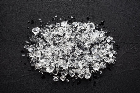 Crushed ice on black stone table top view