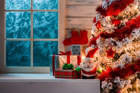 Christmas scene with tree gifts and frozen window in backgroundの写真素材