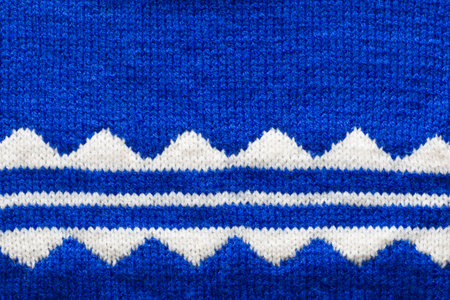 Blue knitted fabric with white pattern, texture or background.