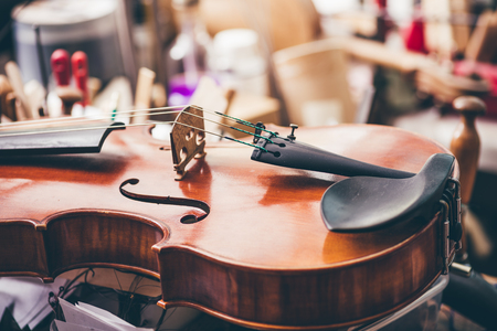 Close up of violin, luthier workshop in backgroundの写真素材
