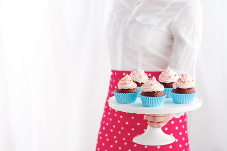 Waitress showing a plate of cupcakes