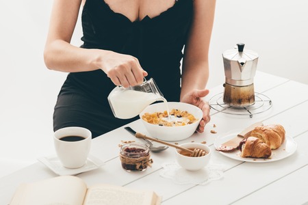 Woman having breakfast. Window lightの写真素材