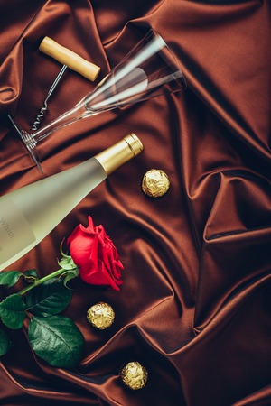 Rose, wine, petals and strawberry on satin fabricの写真素材