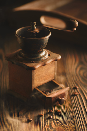 Coffee grinder and bag of roasted coffee on wooden table.の写真素材