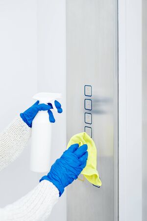 Close up hand of woman disinfecting lift pushの写真素材