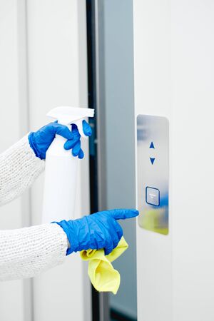 Close up hand of woman disinfecting lift pushの写真素材