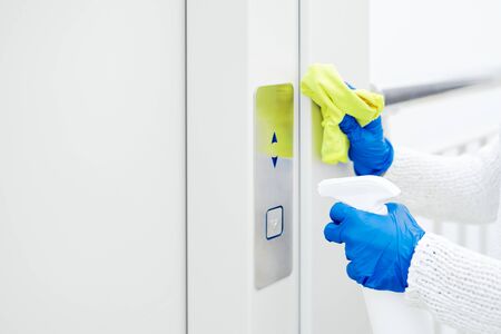 Close up hand of woman disinfecting lift pushの写真素材