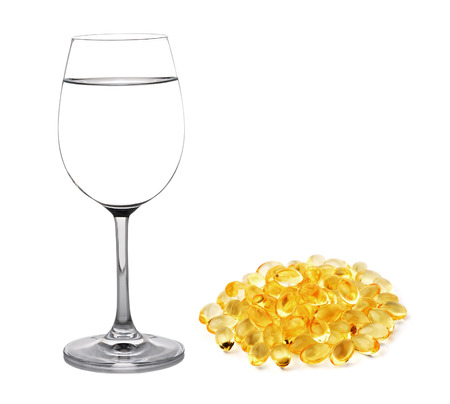 Glass of water and fish oil isolated on white backgroundの写真素材