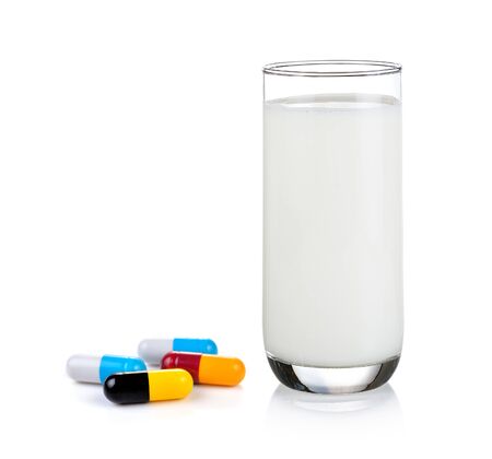 pill and glass of milk isolated on white backgroundの写真素材